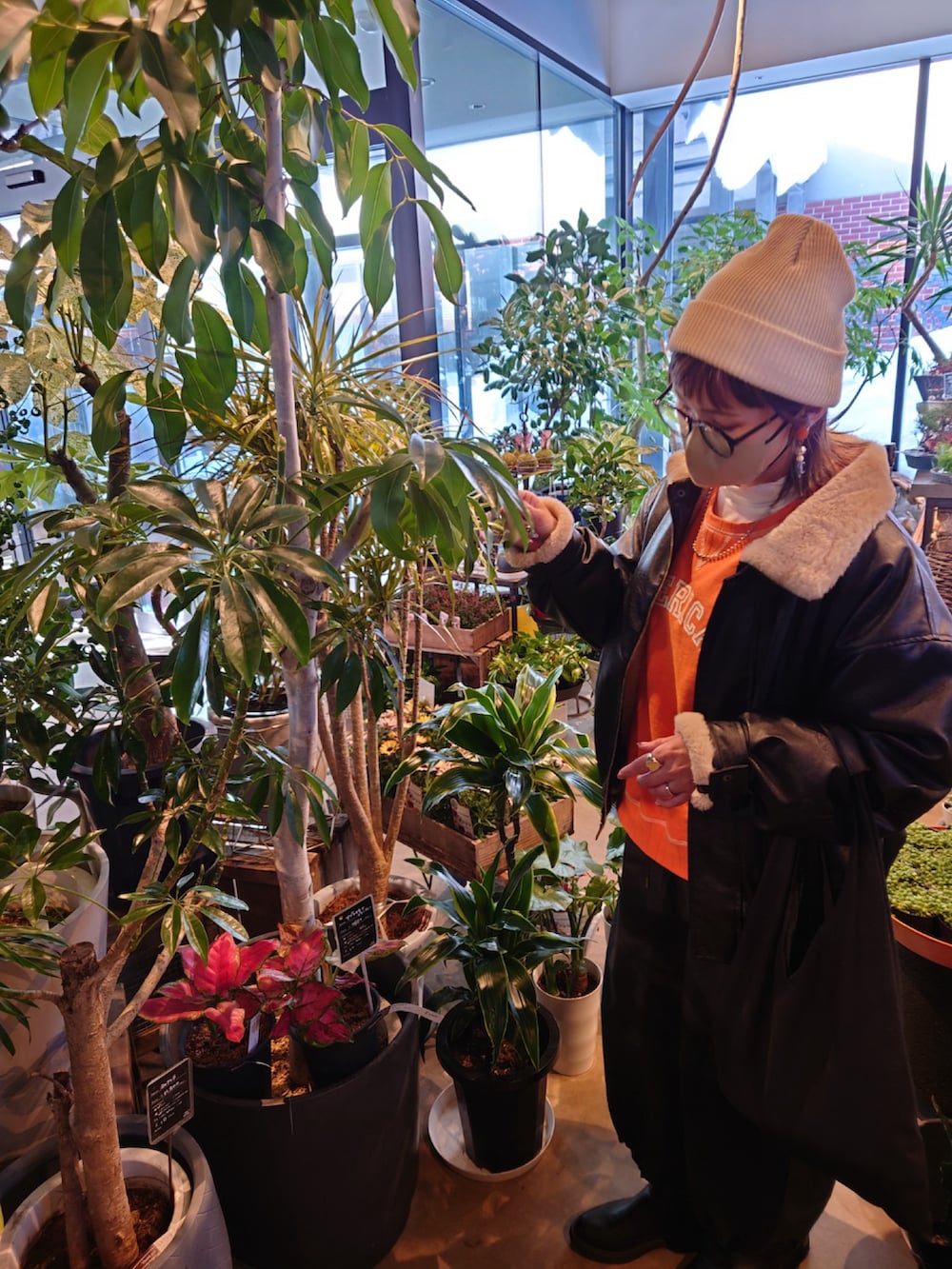 ブラック系のブルゾン、オレンジ系のスウェット、ホワイト系のTシャツ/カットソーを着用したレディースの冬コーディネートの3枚目の写真