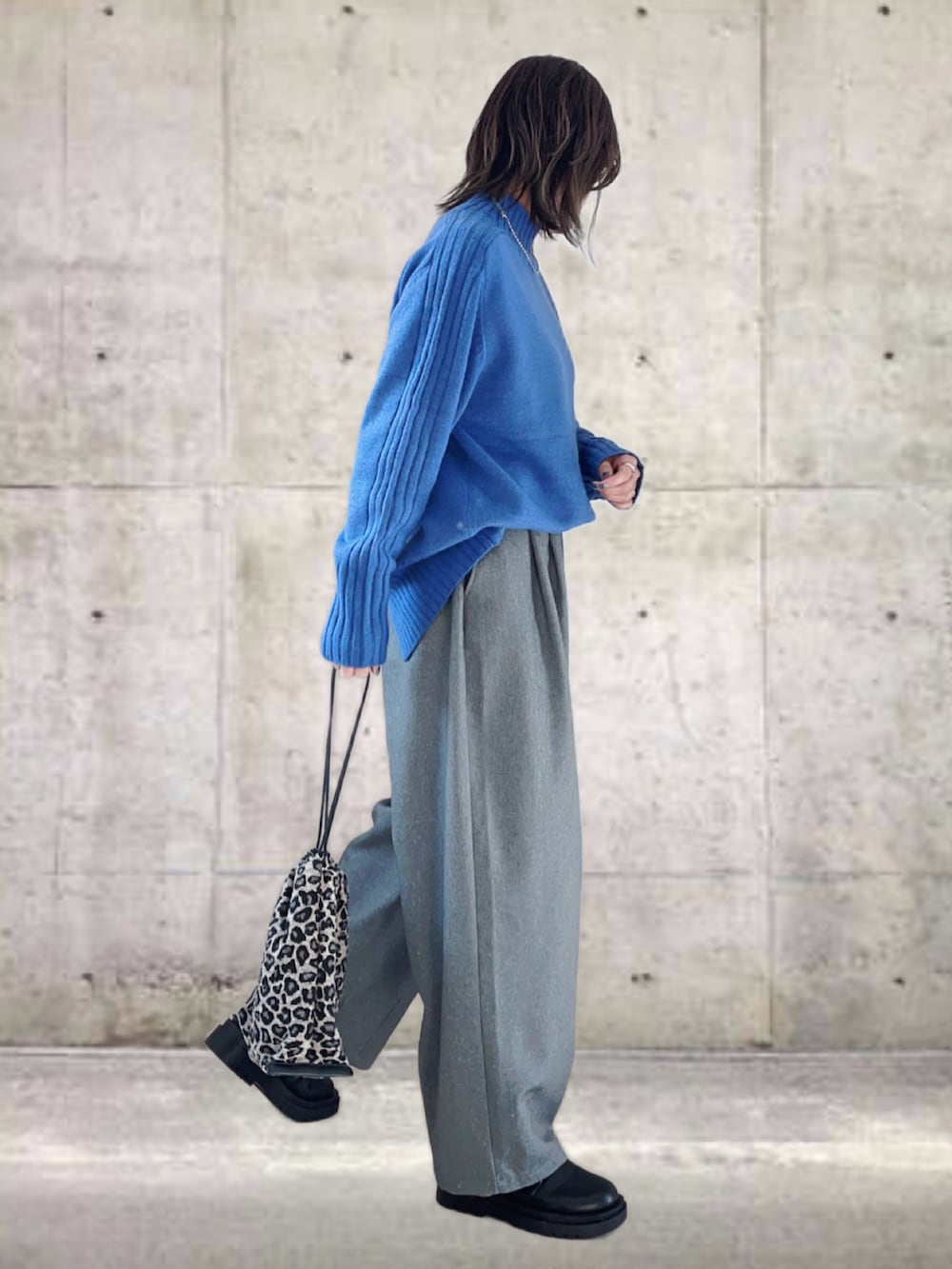 ブルー系のニット/セーター、グレー系のその他パンツ、ブラック系のブーツを着用したレディースの冬コーディネートの3枚目の写真