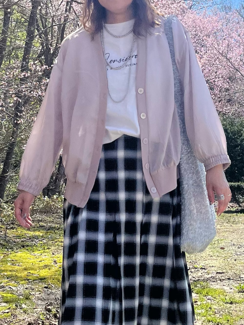 ベージュ系のブルゾン、ホワイト系のTシャツ/カットソー、グレー系のスカートを着用したレディースの春コーディネートの3枚目の写真