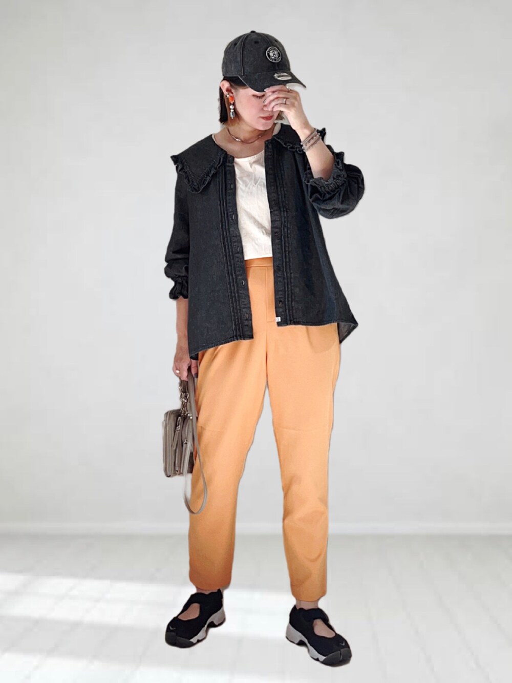 ブラック系のシャツ/ブラウス、ホワイト系のタンクトップ、オレンジ系のスラックスを着用したレディースの夏コーディネートの3枚目の写真