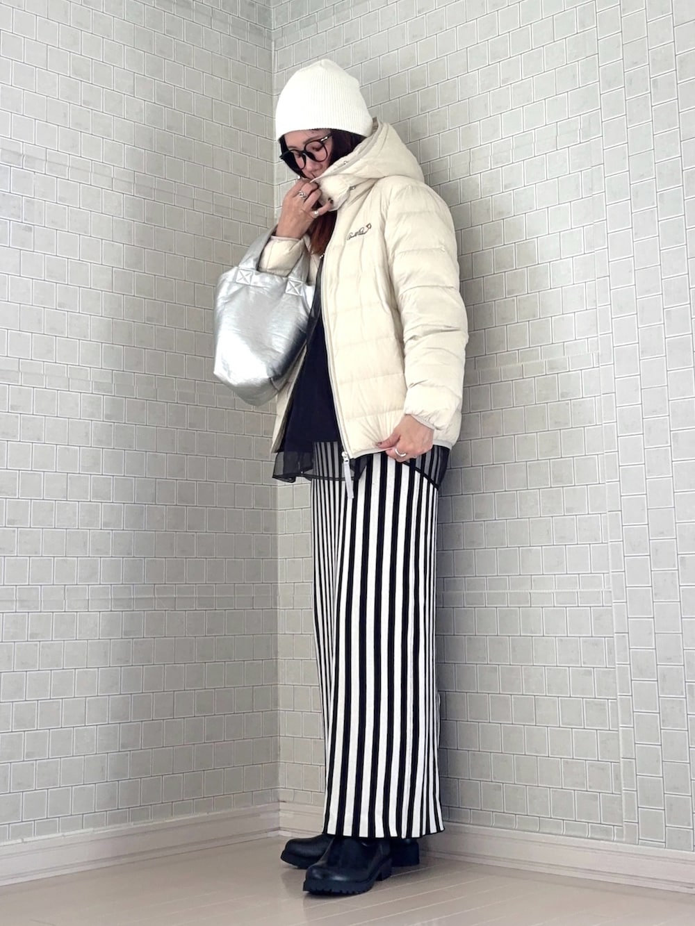 ホワイト系のダウンジャケット/コート、ブラック系のスウェット、ホワイト系のスカートを着用したレディースの秋コーディネートの3枚目の写真