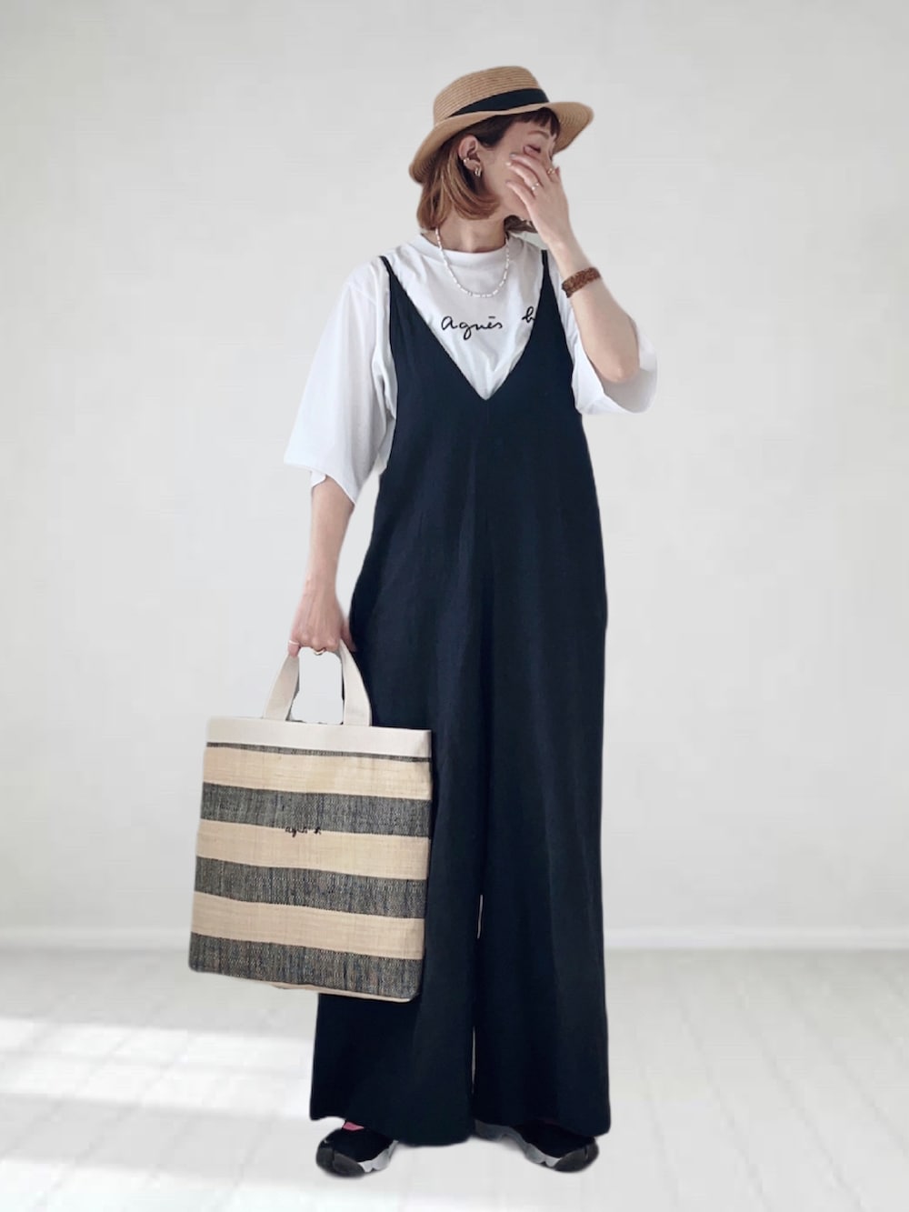 ホワイト系のTシャツ/カットソー、ブラック系のトートバッグ、ブラック系のサロペット/オーバーオールを着用したレディースの春コーディネートの2枚目の写真