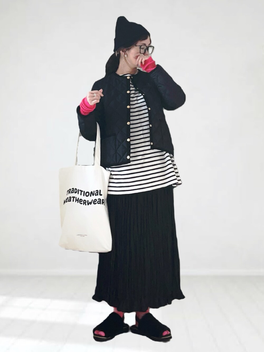 ブラック系のノーカラージャケット、ホワイト系のTシャツ/カットソー、ブラック系のスカートを着用したレディースの秋コーディネートの4枚目の写真