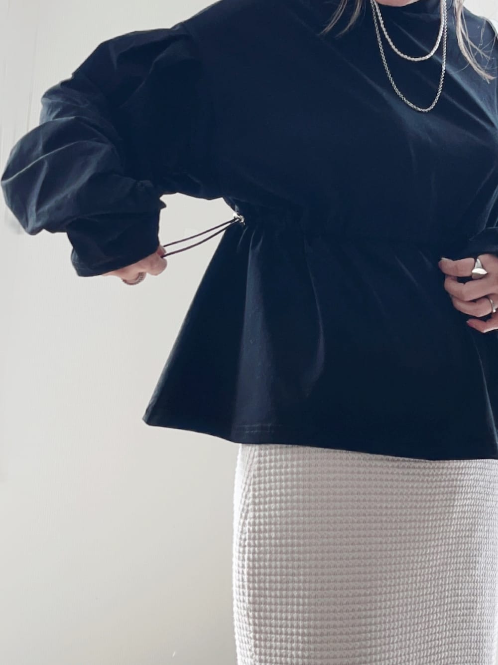 ブラック系のTシャツ/カットソー、ホワイト系のスカート、グレー系のデニムパンツを着用したレディースの春コーディネートの5枚目の写真