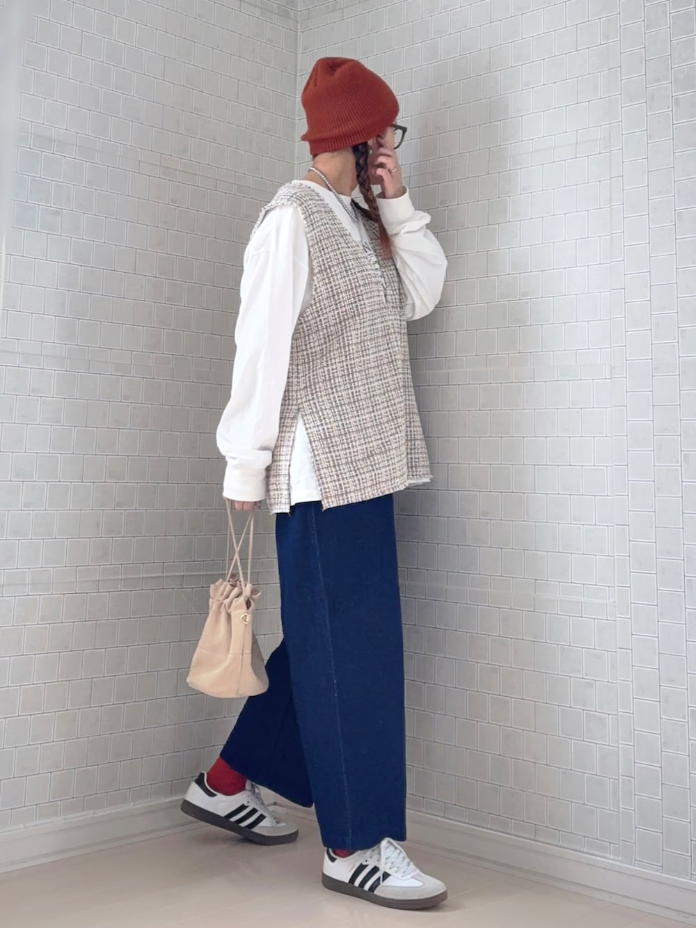 ブルー系のチノパンツ、ホワイト系のスニーカー、ブラウン系のニットキャップ/ビーニーを着用したレディースの冬コーディネートの4枚目の写真