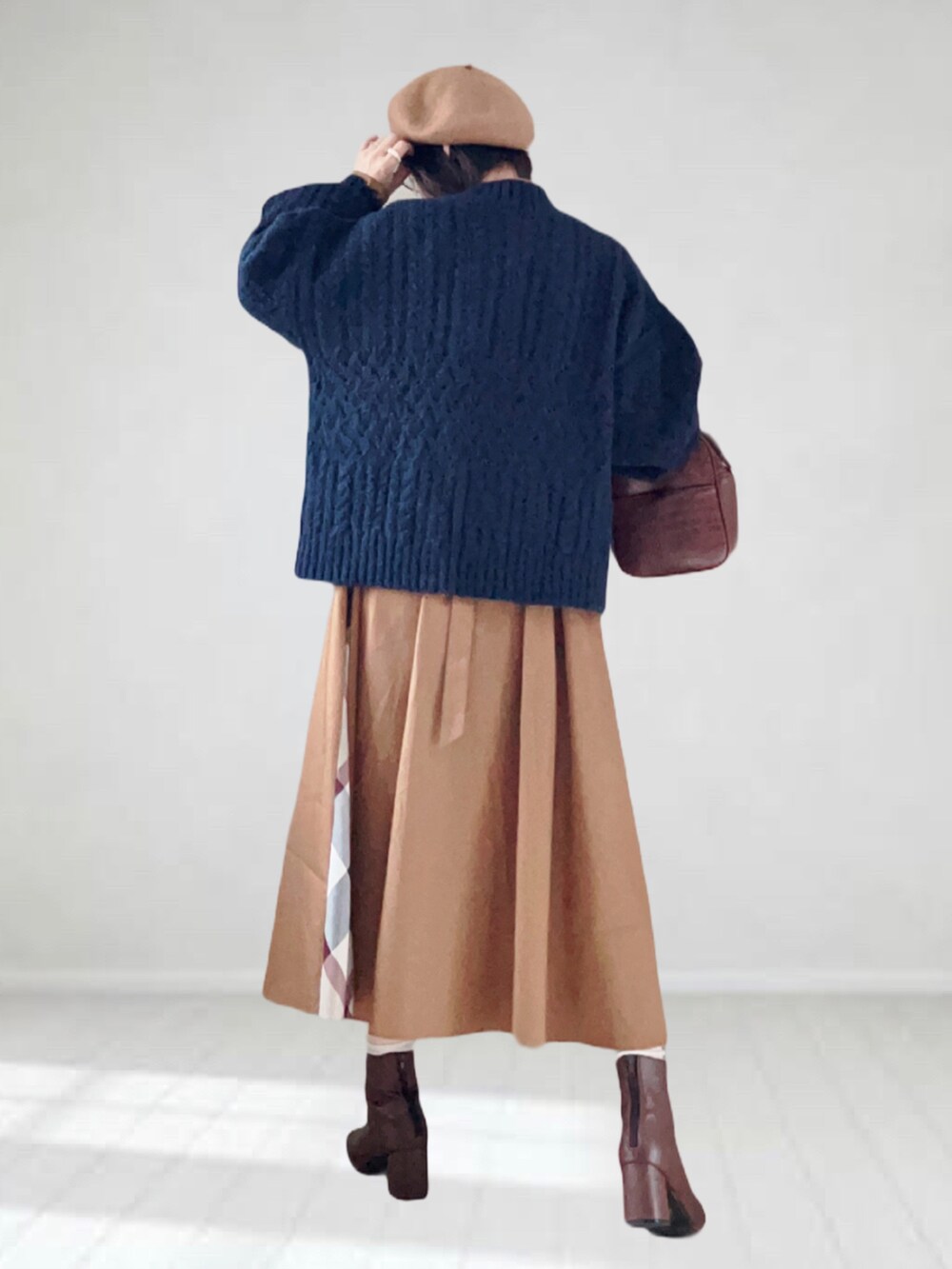 ベージュ系のワンピース、ブルー系のニット/セーター、ブラウン系のハンドバッグを着用したレディースの秋コーディネートの3枚目の写真