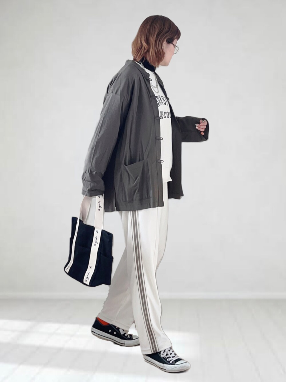 ブラック系のトートバッグ、ブラック系のTシャツ/カットソー、ホワイト系のスウェットを着用したレディースの春コーディネートの2枚目の写真