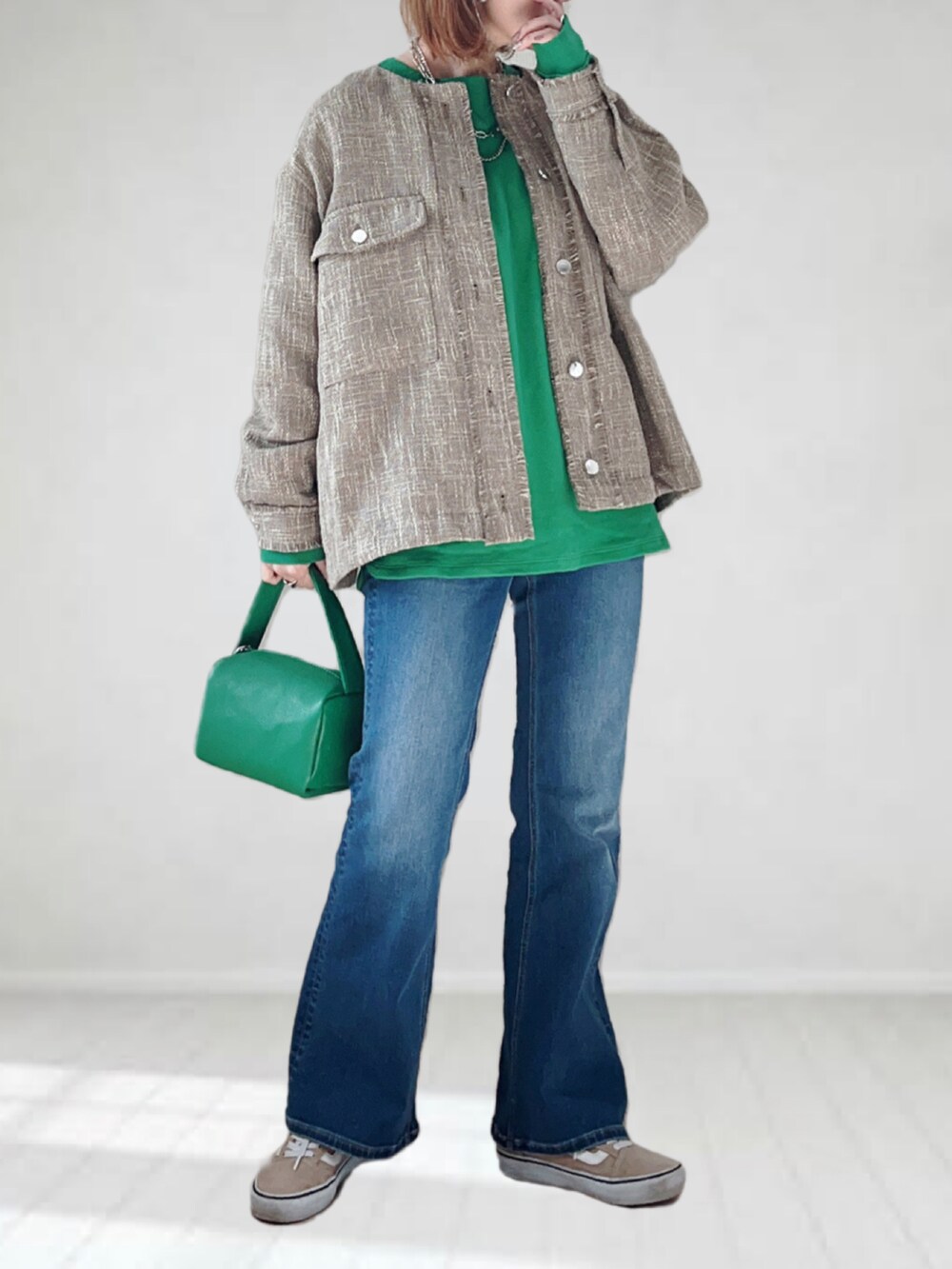 ブルー系のデニムパンツ、グリーン系のTシャツ/カットソー、グリーン系のショルダーバッグを着用したレディースの春コーディネートの2枚目の写真