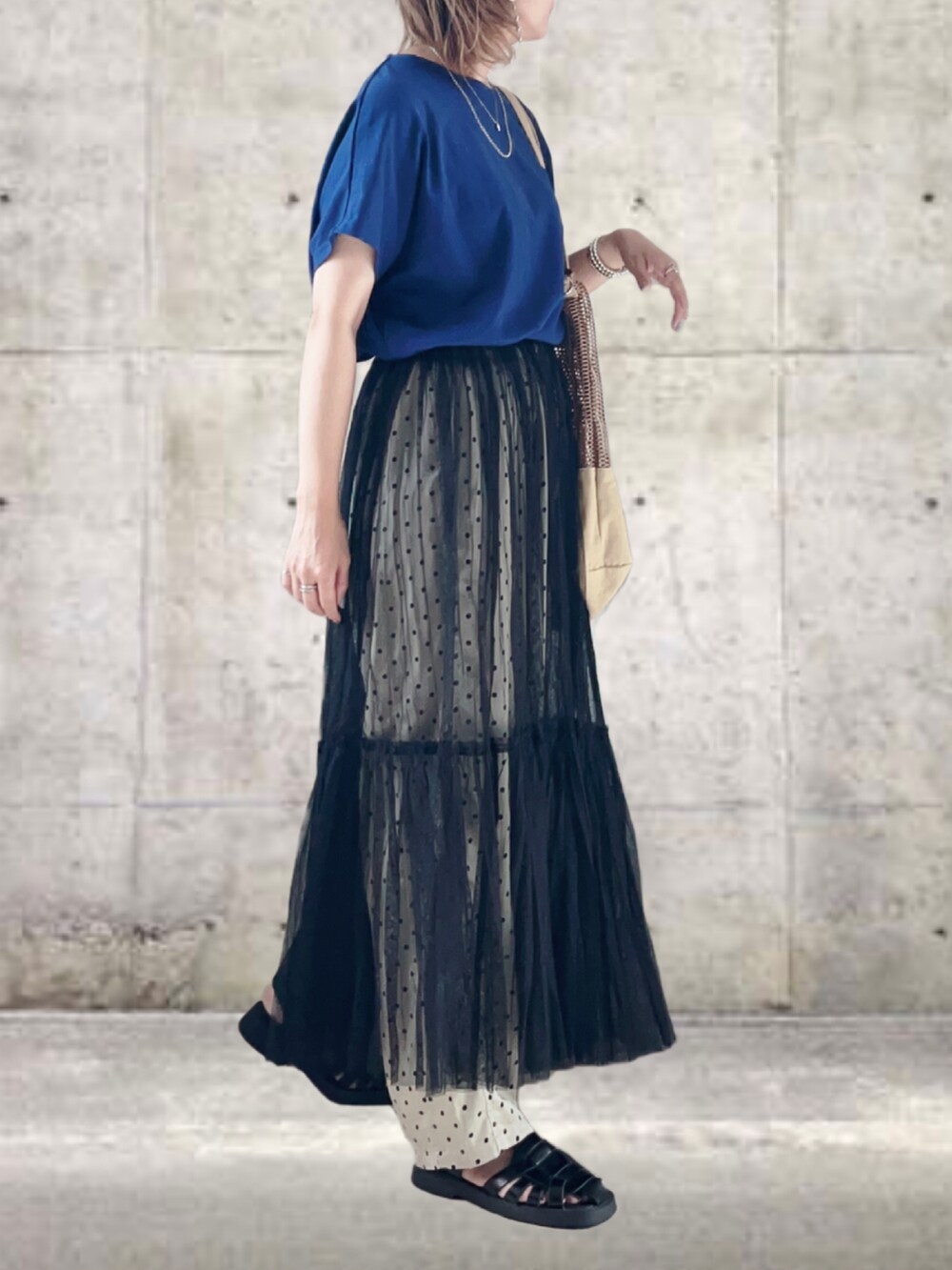 ブルー系のTシャツ/カットソー、ブラック系のスカート、ベージュ系のその他パンツを着用したレディースの秋コーディネートの2枚目の写真