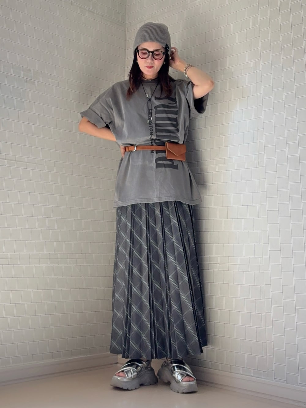 グレー系のスカート、グレー系のTシャツ/カットソー、シルバー系のサンダルを着用したレディースの夏コーディネートの5枚目の写真
