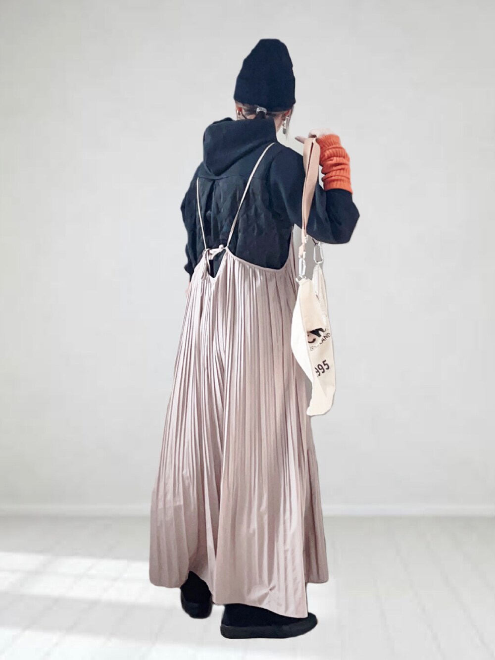 ブラック系のパーカー、ブラウン系のワンピース、ベージュ系のトートバッグを着用したレディースの秋コーディネートの2枚目の写真