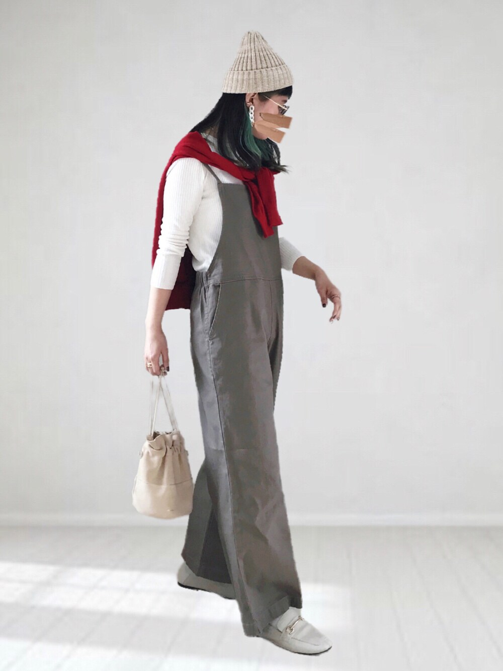 ホワイト系のニット/セーター、レッド系のカーディガン/ボレロ、グリーン系のサロペット/オーバーオールを着用したレディースの冬コーディネートの3枚目の写真