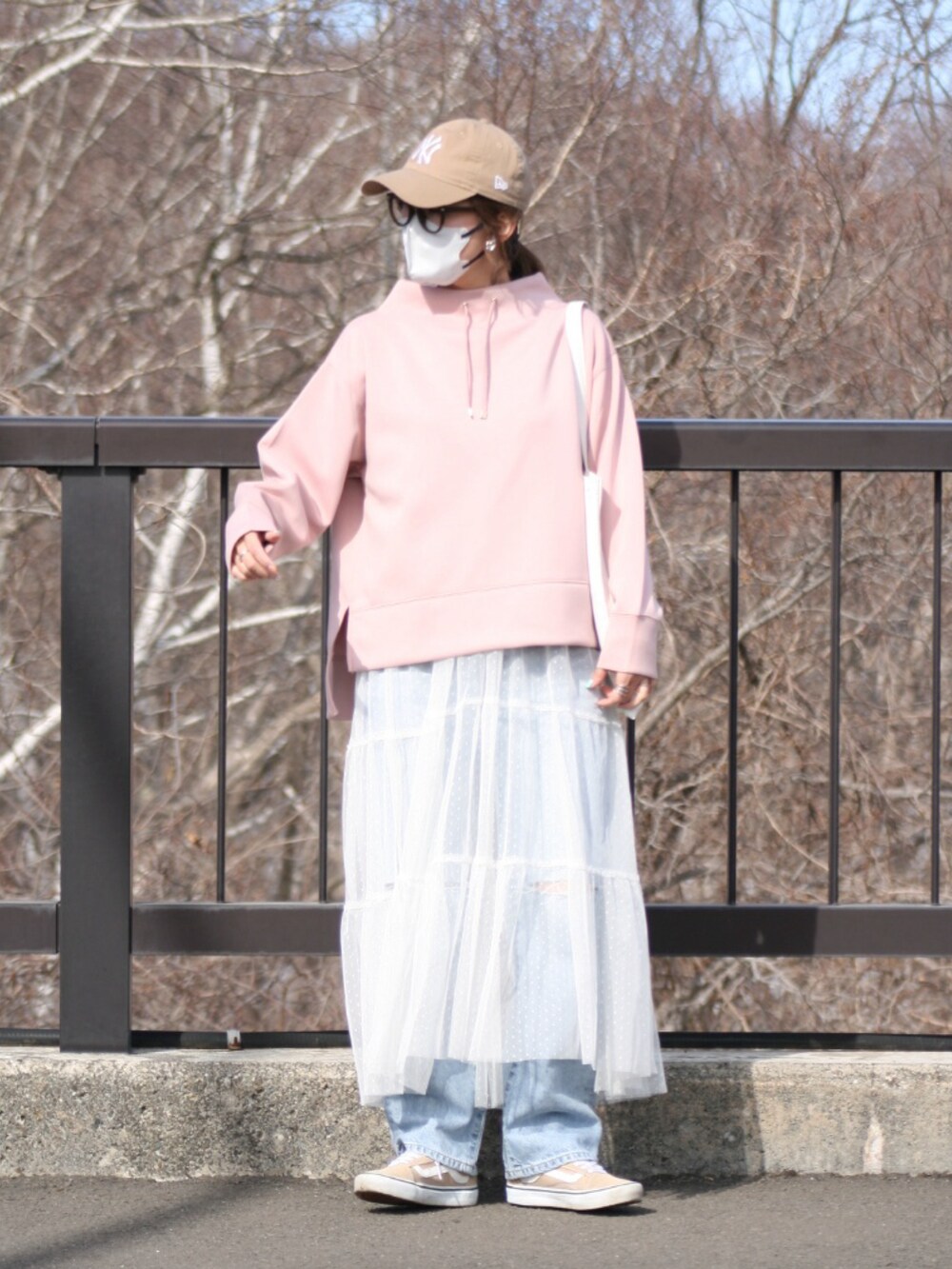 ピンク系のスウェット、ブルー系のデニムパンツ、ホワイト系のワンピース/ドレスを着用したレディースの春コーディネートの4枚目の写真