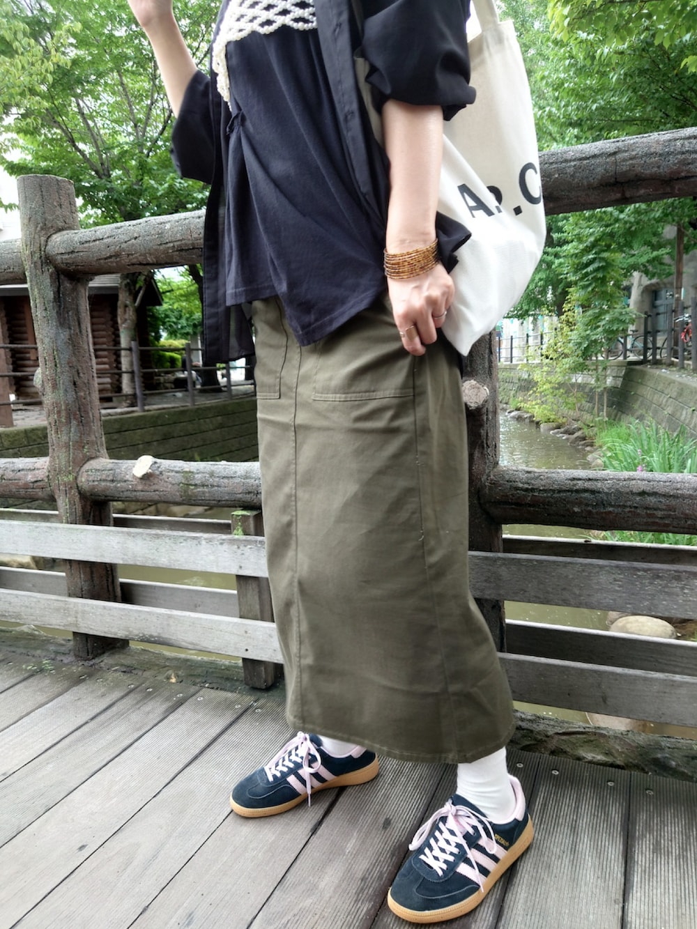 グリーン系のスカート、ブラック系のシャツ/ブラウス、ブラック系のTシャツ/カットソーを着用したレディースの秋コーディネートの3枚目の写真