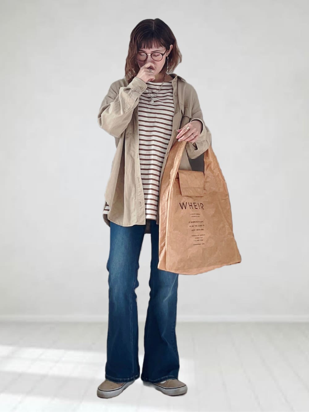 ブルー系のデニムパンツ、ブラウン系のTシャツ/カットソー、ベージュ系のシャツ/ブラウスを着用したレディースの春コーディネートの3枚目の写真