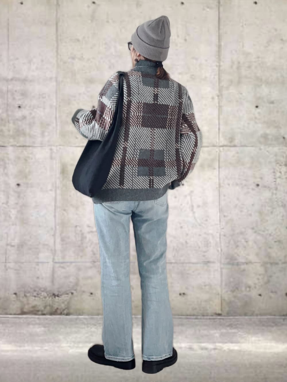 グレー系のニット/セーター、ブルー系のデニムパンツ、ブラック系のトートバッグを着用したレディースの冬コーディネートの3枚目の写真