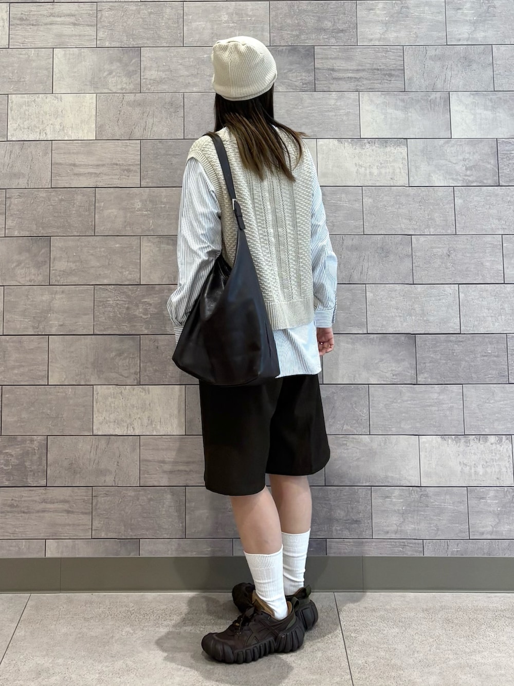 ベージュ系のTシャツ/カットソー、ブラウン系のショルダーバッグ、ブラウン系のスニーカーを着用したレディースの春コーディネートの3枚目の写真