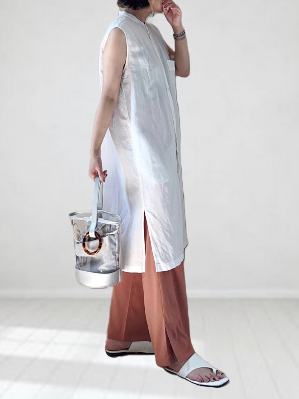 ホワイト系のシャツ/ブラウス、オレンジ系のその他パンツ、シルバー系のショルダーバッグを着用したレディースの夏コーディネートの3枚目の写真