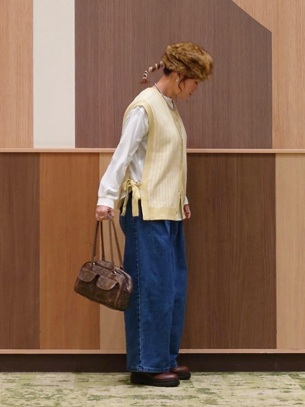 グリーン系のベスト、ブルー系のデニムパンツ、ホワイト系のシャツ/ブラウスを着用したレディースの冬コーディネートの5枚目の写真