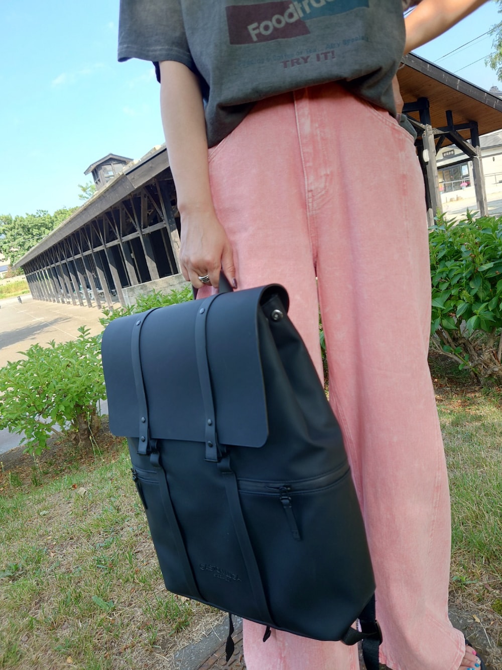 ブラック系のバックパック/リュック、グレー系のTシャツ/カットソー、ブラック系のサンダルを着用したレディースの夏コーディネートの3枚目の写真