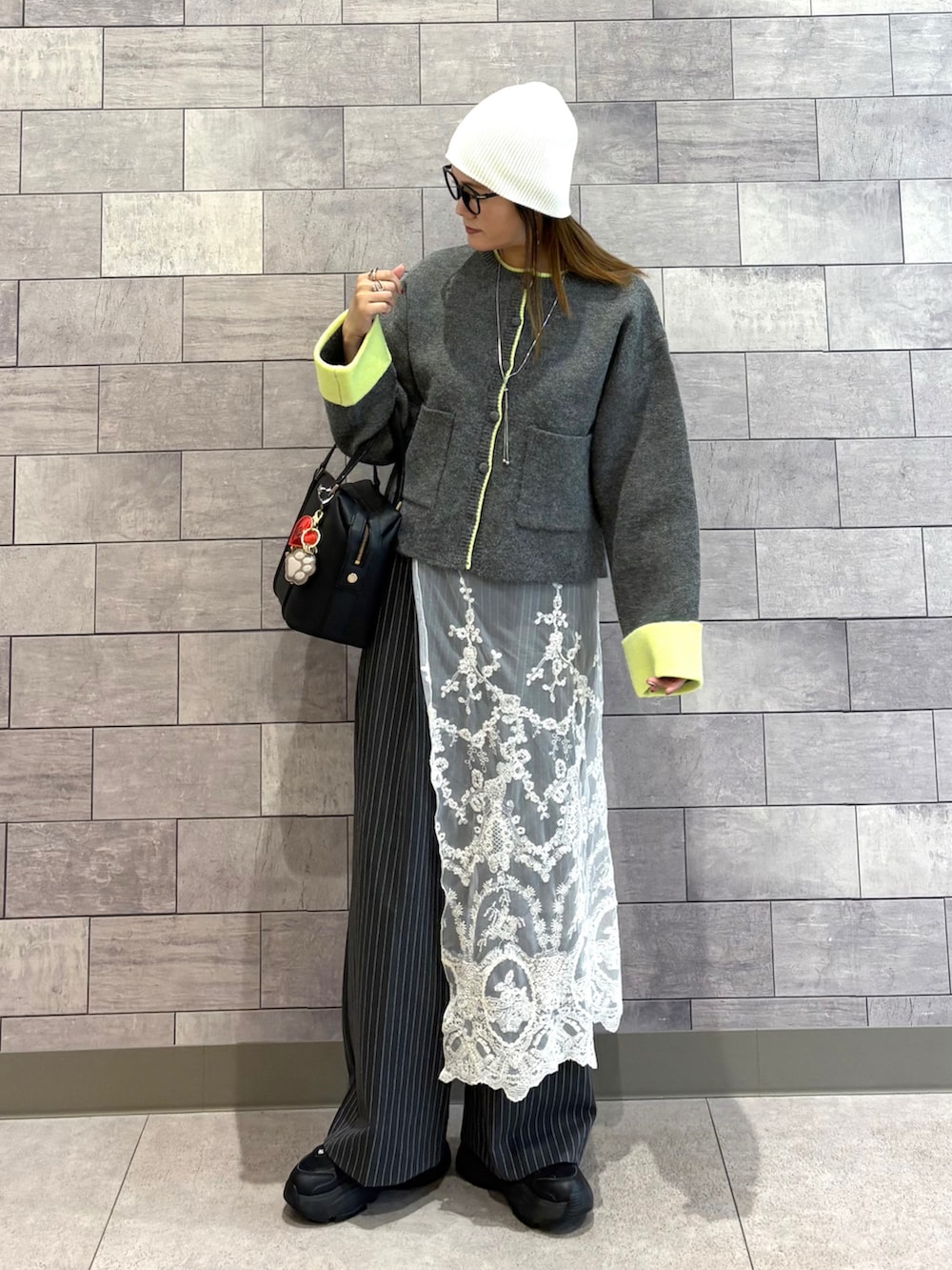 グレー系のカーディガン/ボレロ、グレー系のその他パンツ、ブラック系のボストンバッグを着用したレディースの秋コーディネートの2枚目の写真