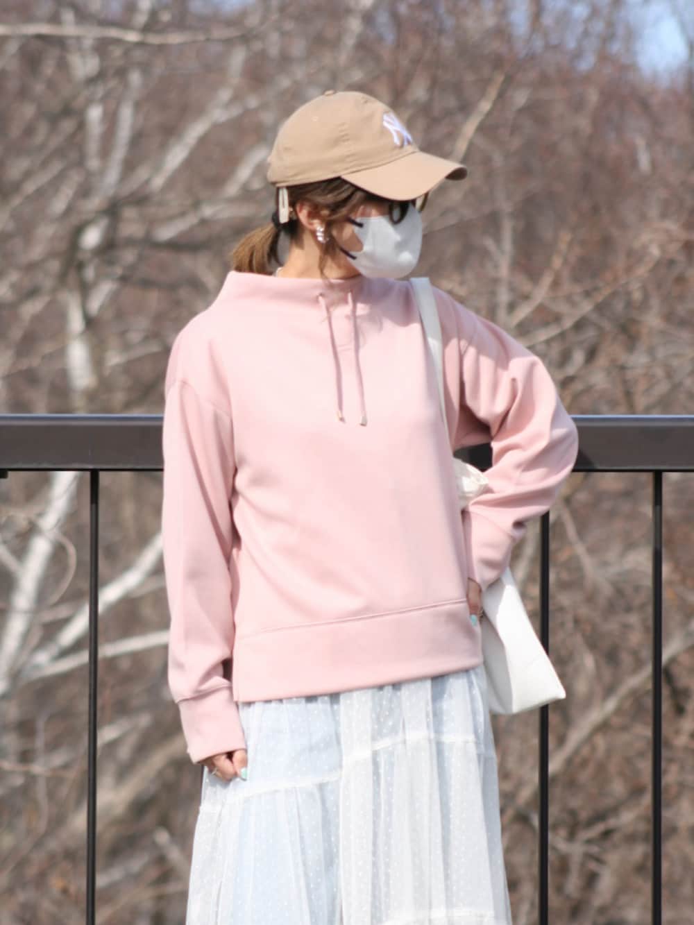 ピンク系のスウェット、ブルー系のデニムパンツ、ホワイト系のワンピース/ドレスを着用したレディースの春コーディネートの5枚目の写真