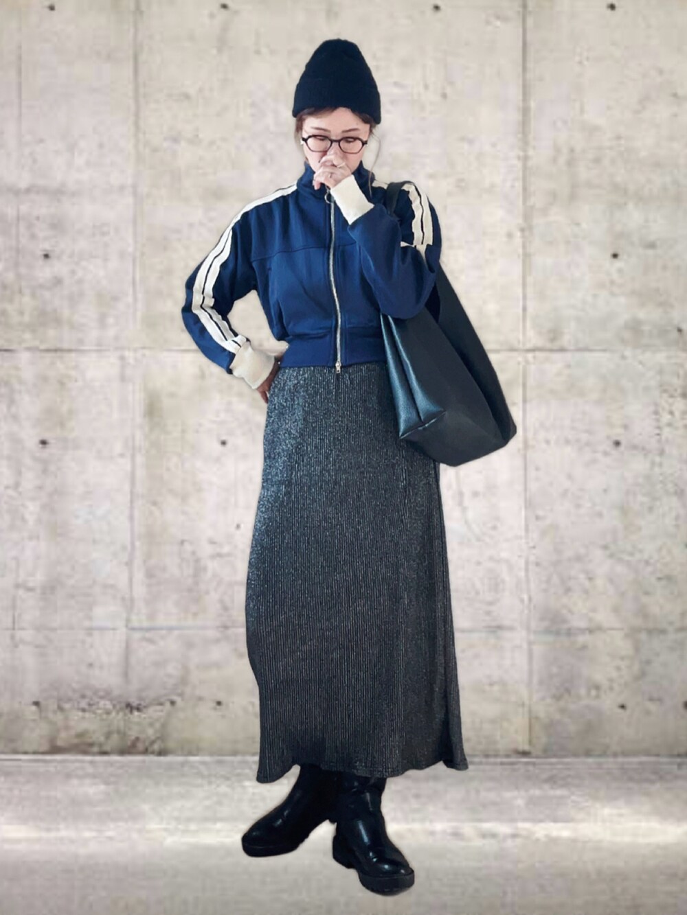ブルー系のブルゾン、グレー系のスカート、ブラック系のトートバッグを着用したレディースの冬コーディネートの2枚目の写真