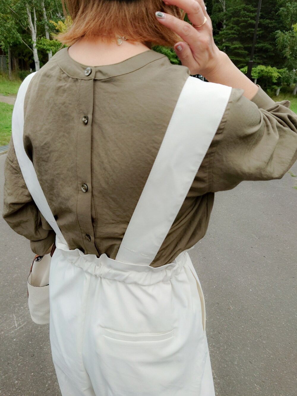 グリーン系のシャツ/ブラウス、ホワイト系のその他パンツ、ホワイト系のハンドバッグを着用したレディースの秋コーディネートの3枚目の写真