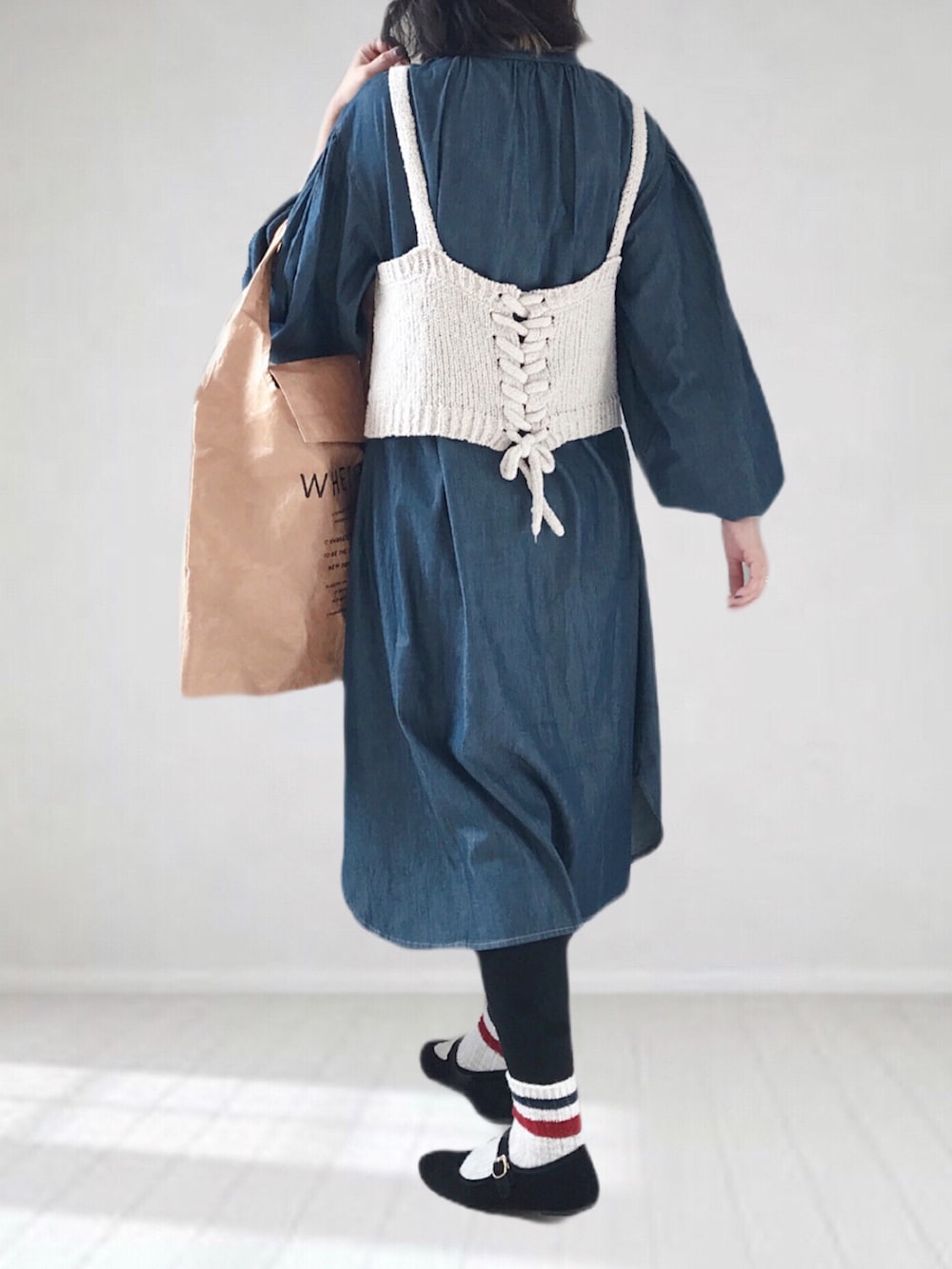 ブルー系のワンピース、ベージュ系のトートバッグ、ホワイト系のキャミソールを着用したレディースの春コーディネートの2枚目の写真