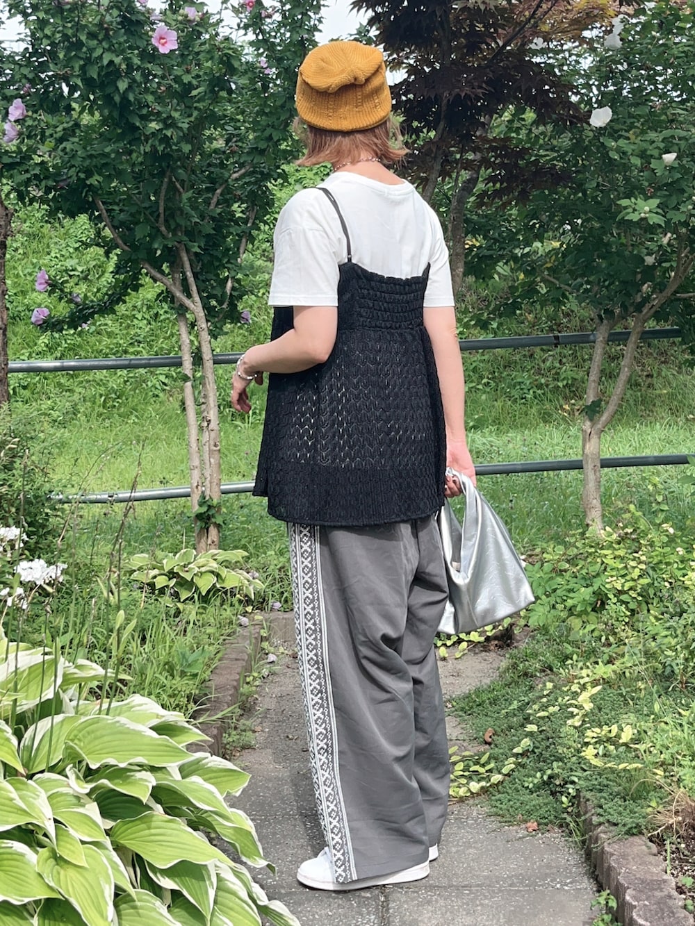 グレー系のその他パンツ、ブラック系のTシャツ/カットソー、ホワイト系のスニーカーを着用したレディースの夏コーディネートの3枚目の写真