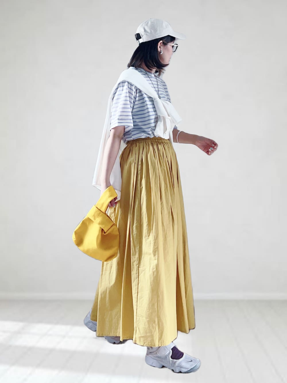 パープル系のTシャツ/カットソー、ホワイト系のシャツ/ブラウス、イエロー系のスカートを着用したレディースの春コーディネートの3枚目の写真