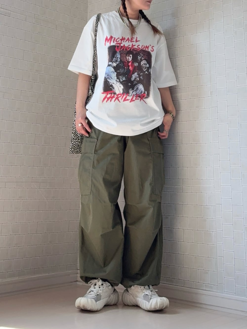 ホワイト系のTシャツ/カットソー、ホワイト系のスニーカー、ブラック系のベストを着用したレディースの夏コーディネートの3枚目の写真