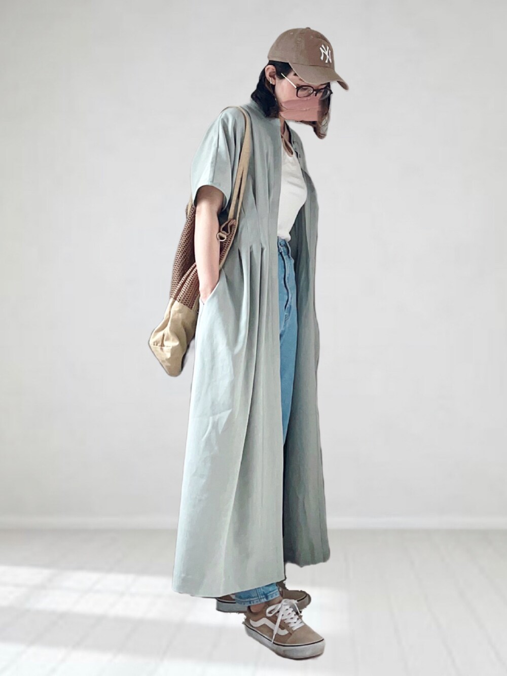 グリーン系のワンピース、ホワイト系のキャミソール、ブルー系のデニムパンツを着用したレディースの夏コーディネートの2枚目の写真