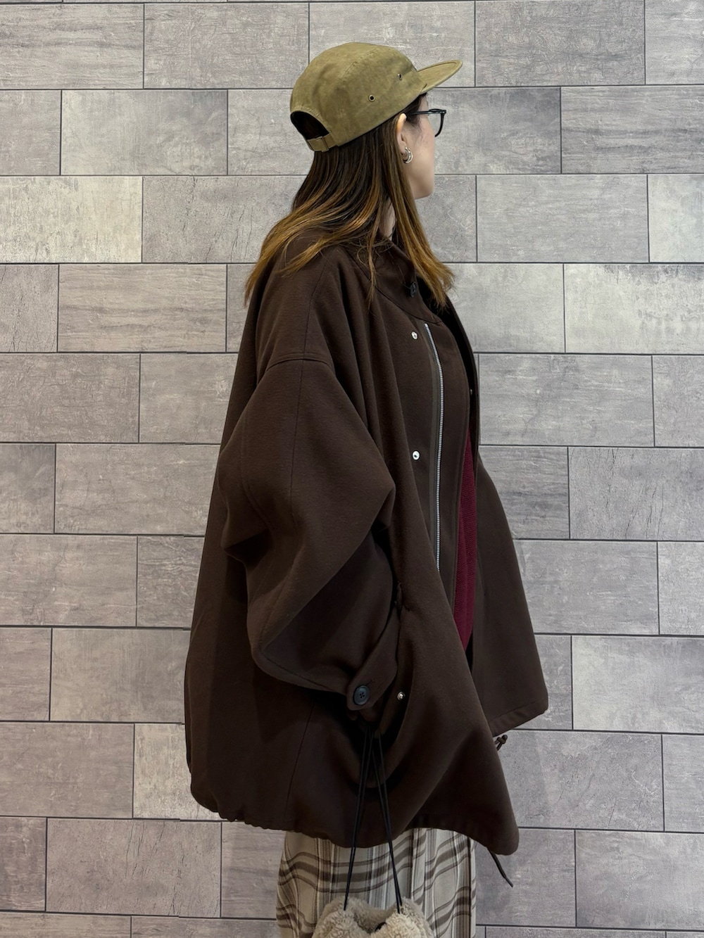 ブラウン系のモッズコート、レッド系のニット/セーター、ベージュ系のその他パンツを着用したレディースの冬コーディネートの4枚目の写真