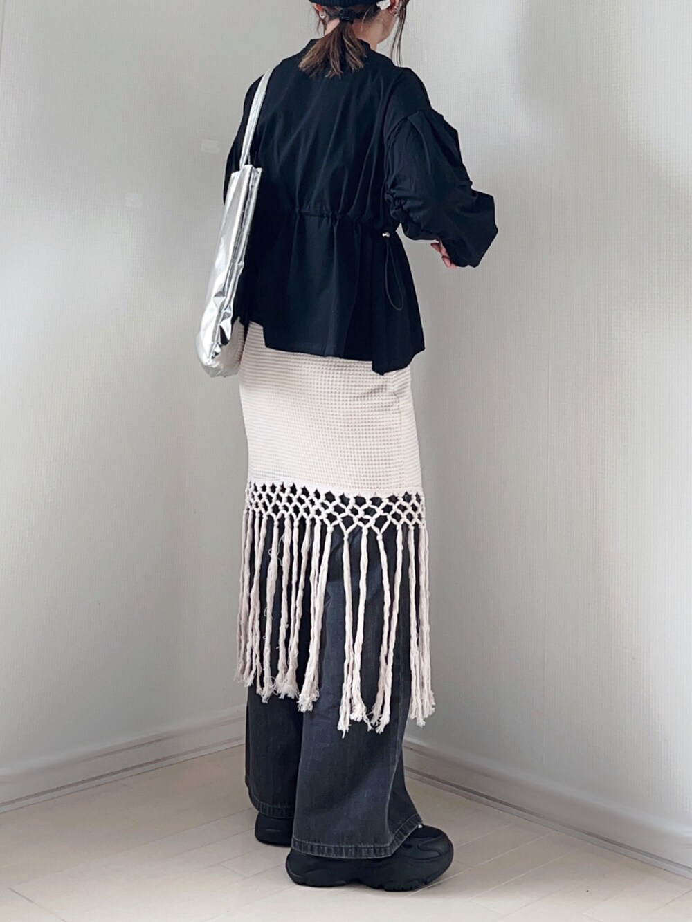 ブラック系のTシャツ/カットソー、ホワイト系のスカート、グレー系のデニムパンツを着用したレディースの春コーディネートの4枚目の写真