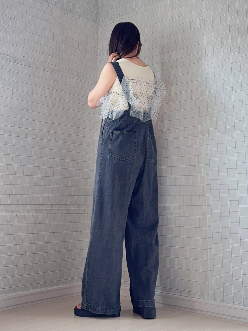 ホワイト系のニット/セーター、グレー系のデニムパンツ、ブラック系のサンダルを着用したレディースの夏コーディネートの4枚目の写真