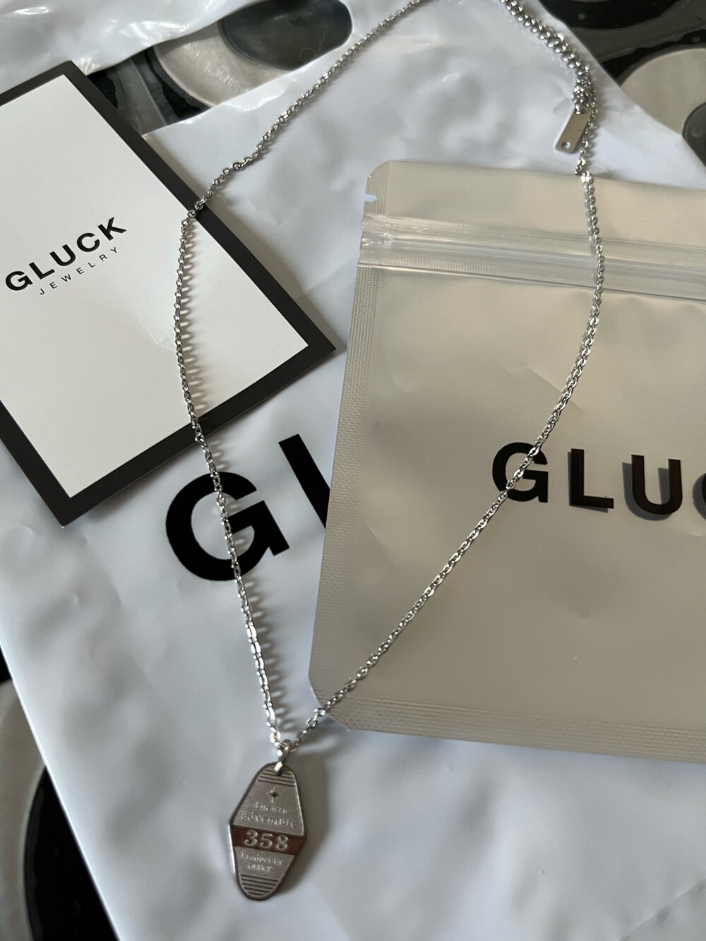 ブラック系のベスト、ブラウン系のスラックス、ホワイト系のTシャツ/カットソーを着用したレディースの夏コーディネートの5枚目の写真