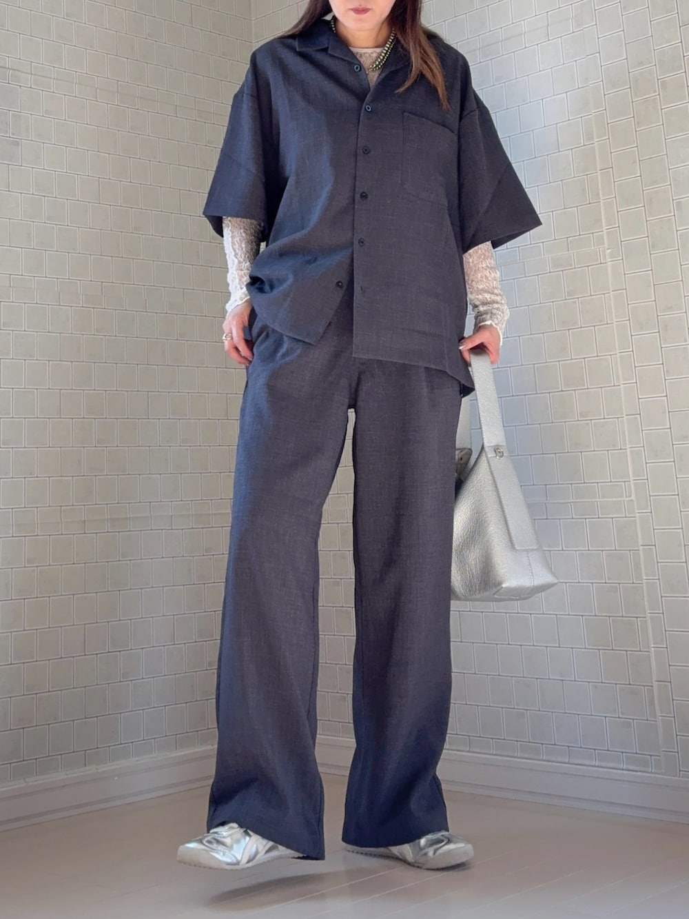 シルバー系のスニーカー、グレー系のシャツ/ブラウス、グレー系のスラックスを着用したレディースの春コーディネートの2枚目の写真