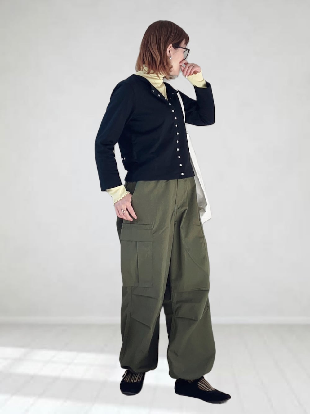 ブラック系のカーディガン/ボレロ、イエロー系のTシャツ/カットソー、グリーン系のカーゴパンツを着用したレディースの春コーディネートの2枚目の写真