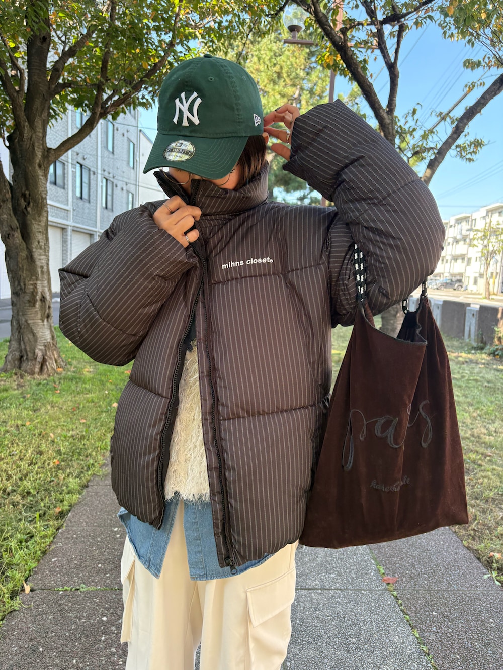 その他のダウンジャケット/コート、ブラック系のスニーカー、ブルー系のシャツ/ブラウスを着用したレディースの秋コーディネートの3枚目の写真