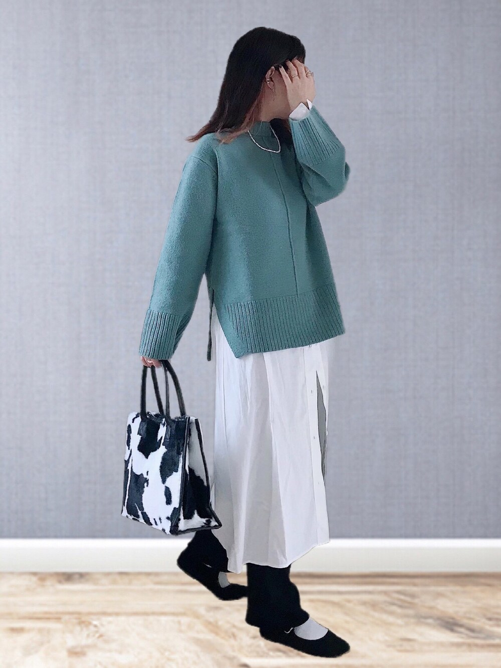 グリーン系のニット/セーター、グレー系のワンピース、ブラック系のその他パンツを着用したレディースの冬コーディネートの2枚目の写真