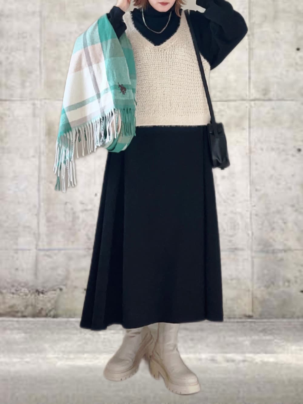 ブラック系のワンピース、ホワイト系のベスト、ブラック系のショルダーバッグを着用したレディースの秋コーディネートの3枚目の写真