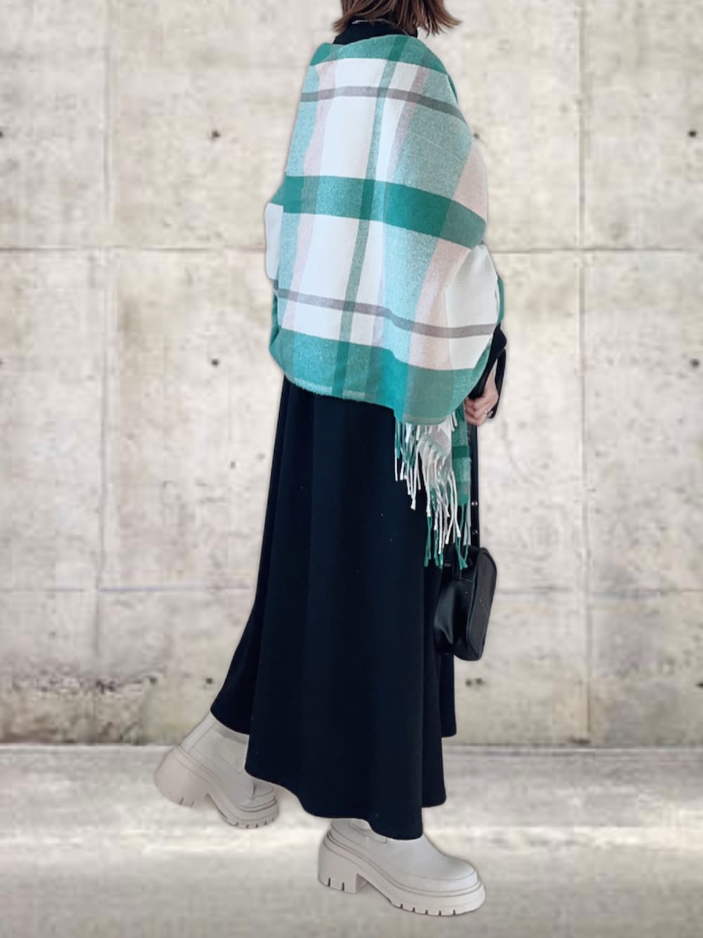 ブラック系のワンピース、ホワイト系のベスト、ブラック系のショルダーバッグを着用したレディースの秋コーディネートの2枚目の写真