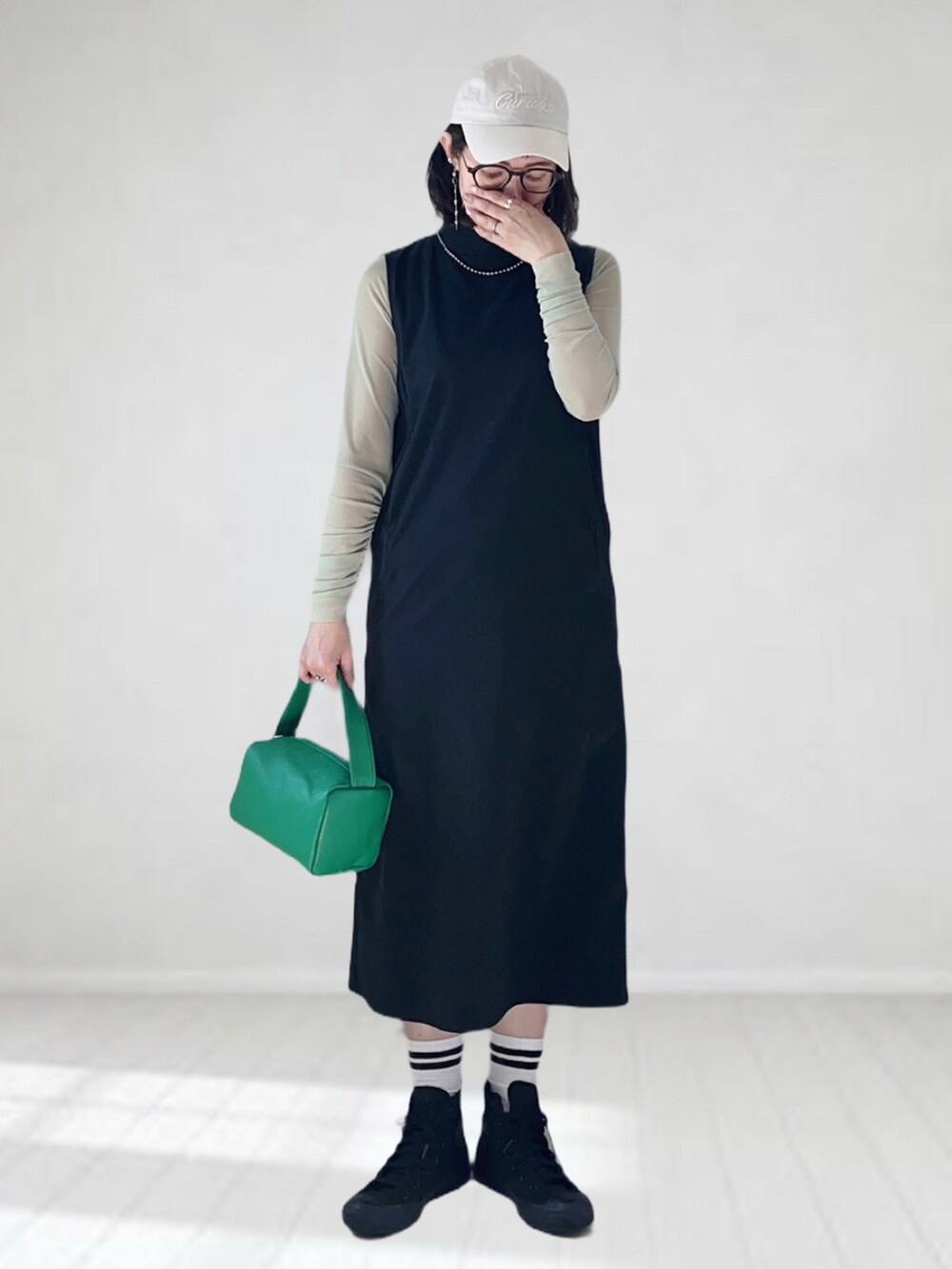 ブラック系のワンピース、グリーン系のTシャツ/カットソー、グリーン系のショルダーバッグを着用したレディースの春コーディネートの3枚目の写真