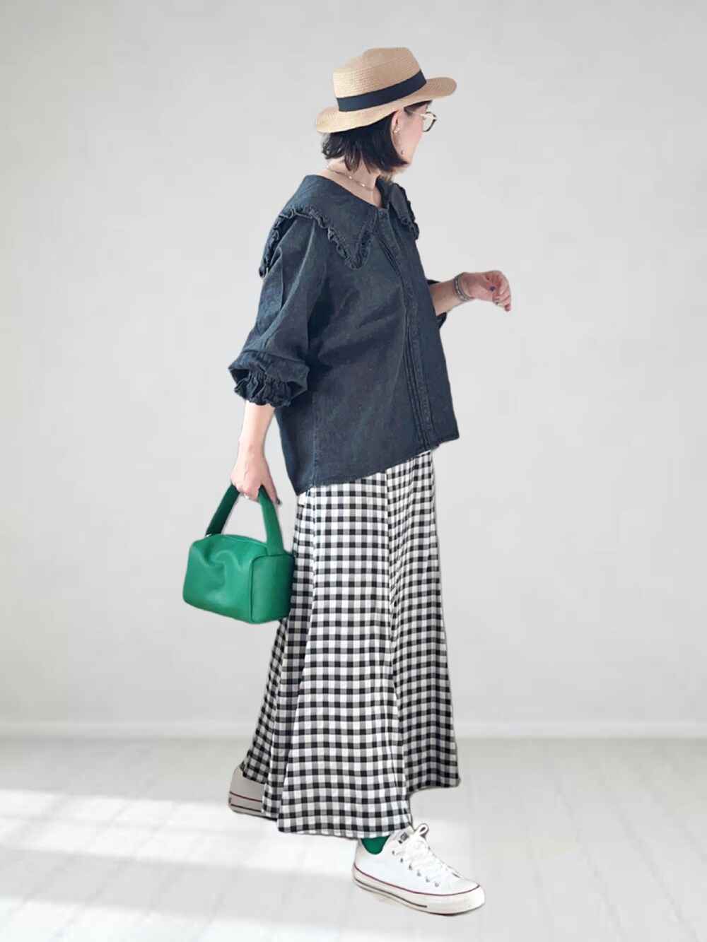 ブラック系のシャツ/ブラウス、ブラック系のスカート、グリーン系のショルダーバッグを着用したレディースの夏コーディネートの2枚目の写真