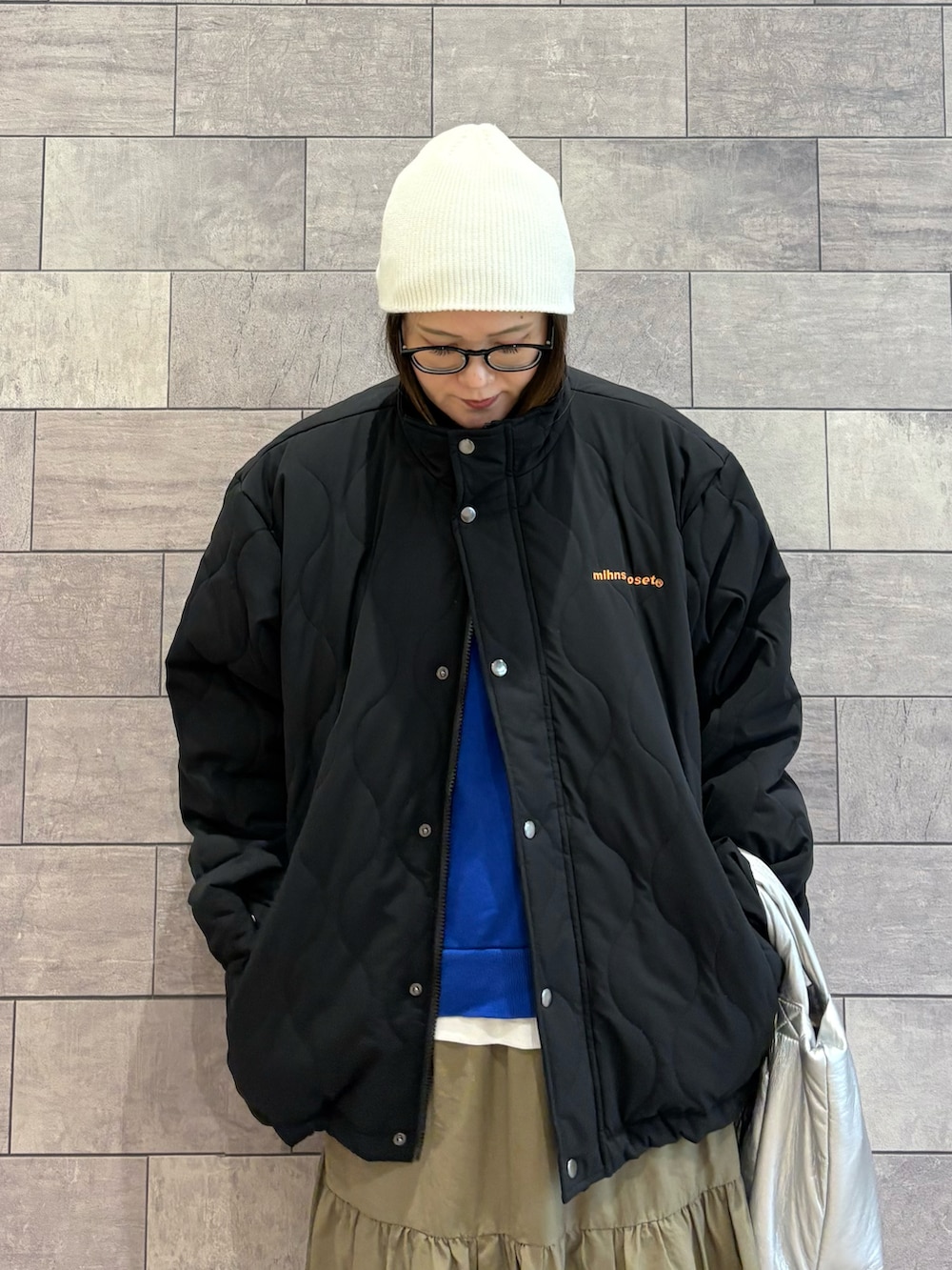 ブラック系のブルゾン、ブルー系のスウェット、グリーン系のスカートを着用したレディースの秋コーディネートの4枚目の写真