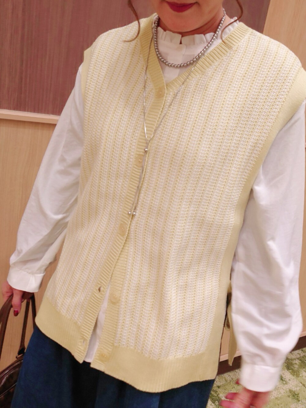 グリーン系のベスト、ブルー系のデニムパンツ、ホワイト系のシャツ/ブラウスを着用したレディースの冬コーディネートの2枚目の写真