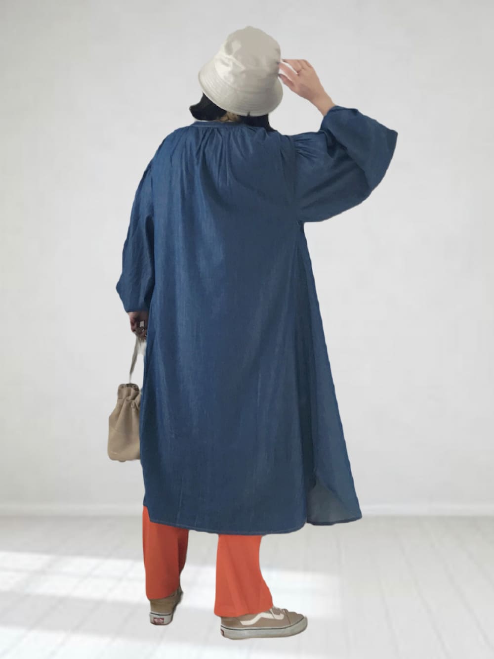 ブルー系のワンピース、グレー系のTシャツ/カットソー、オレンジ系のチノパンツを着用したレディースの春コーディネートの3枚目の写真