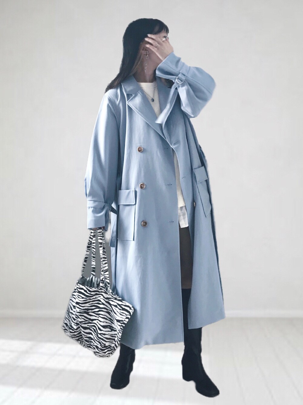 ブルー系のトレンチコート、ホワイト系のTシャツ/カットソー、ホワイト系のTシャツ/カットソーを着用したレディースの冬コーディネートの2枚目の写真