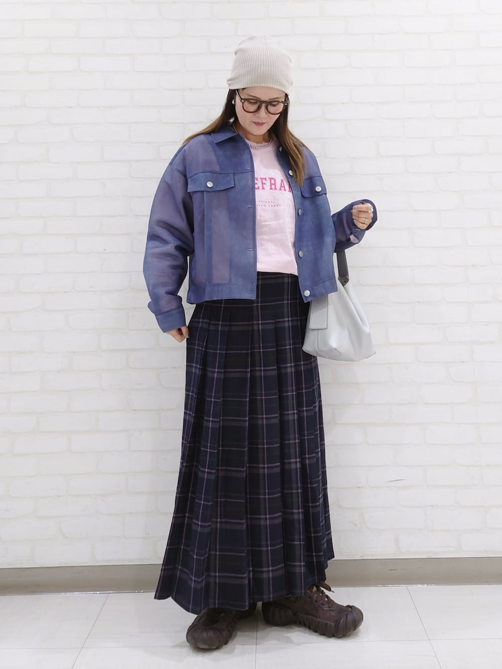 ブルー系のデニムジャケット、ブルー系のスカート、ブラウン系のスニーカーを着用したレディースの春コーディネートの2枚目の写真